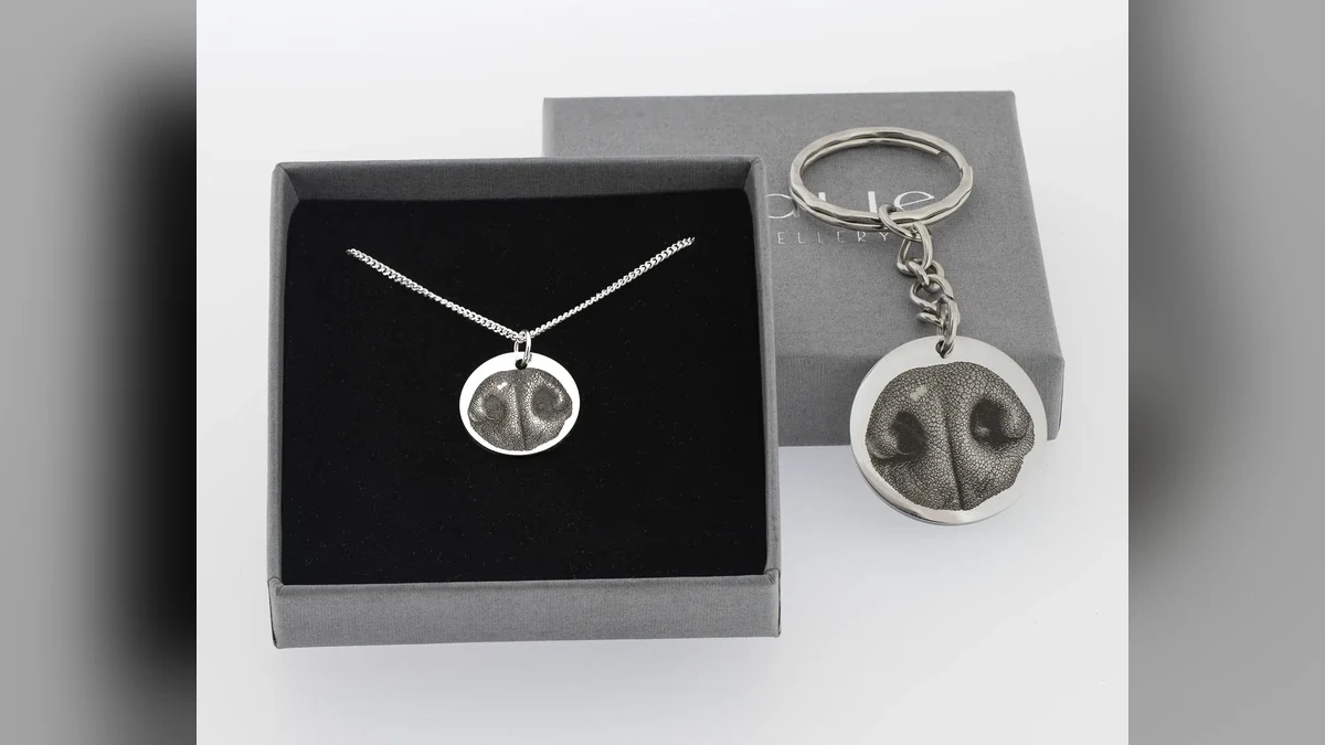 A real dog’s nose beside a pendant engraved from the same nose pattern.